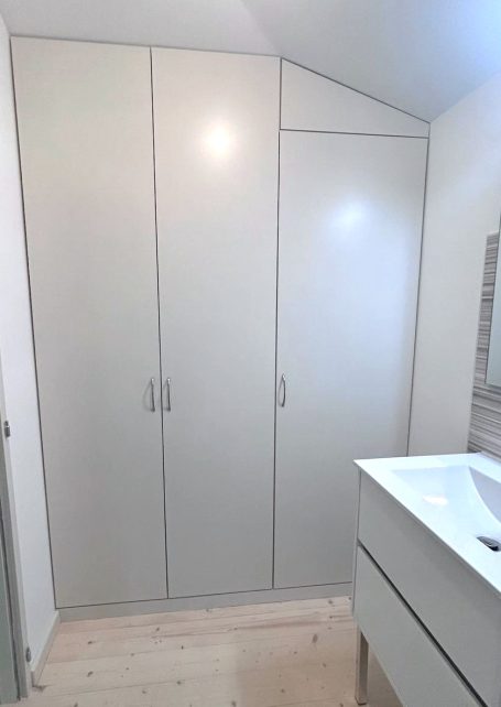 amenagement interieur placard rangement bois sur mesure - guillemot - charente Rangement moderne et épuré avec trois portes près d'un lavabo dans une salle de bain.