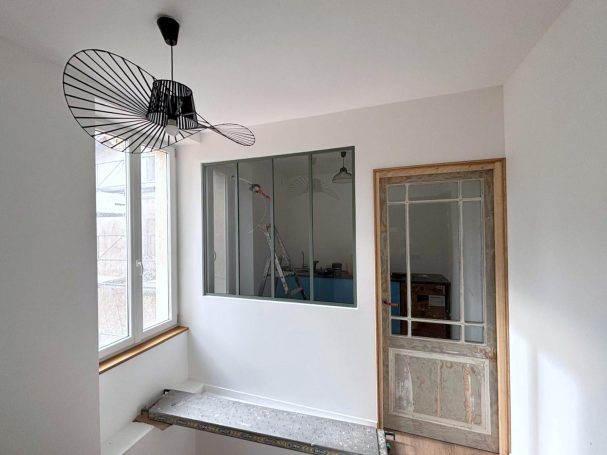 menuiserie interieure guillemot barbezieux renovation maison porte et verriere Chambre lumineuse avec un ventilateur, fenêtre, et porte en bois.