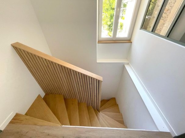 renovation escalier bois maison cognac sarl guillemot Escalier en bois avec rambarde simple, lumineux, vue sur une fenêtre.